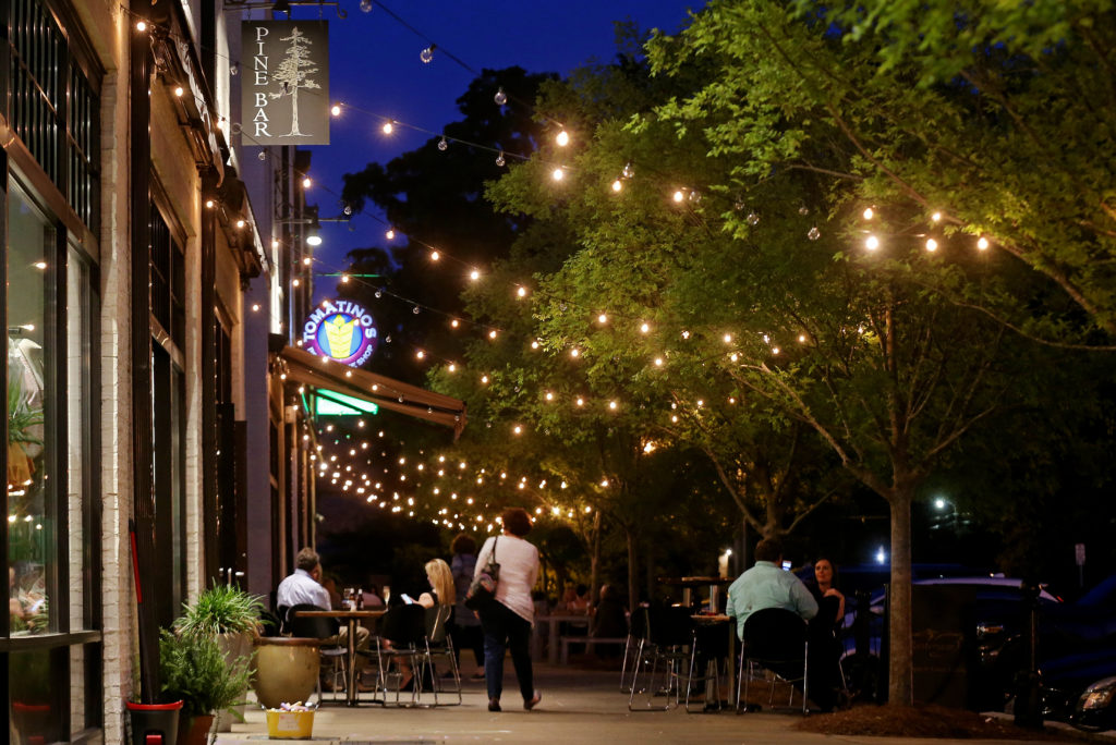 The Pine Bar and Tomatinos light up at night in Montgomery's Old Cloverdale neighborhood on Wednesday, April 25, 2018.The Pine Bar features a variety of draft, craft and high-quality beers, including several from Alabama's fine breweries, champagne and signature cocktails. Opening every day at 4 p.m, except Sunday, The Pine Bar does not have a food menu, but the friendly bartenders are happy for customers to bring in food from any of the eateries that are in the same block, including Tomatinos Pizza, Cafe Louisa, The Vintage Year, Vintage Cafe and Filet and Vine.